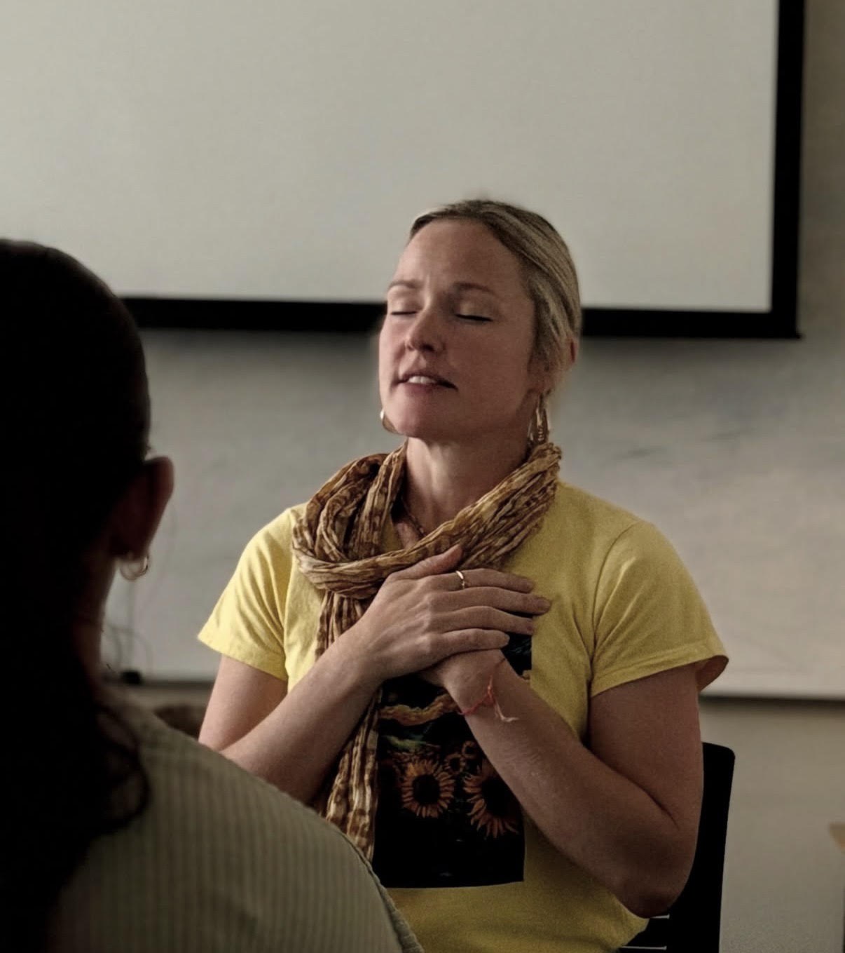 Amrita Keli, a Krishna House alumna, leading a Mindful Monday with her hands over her heart
